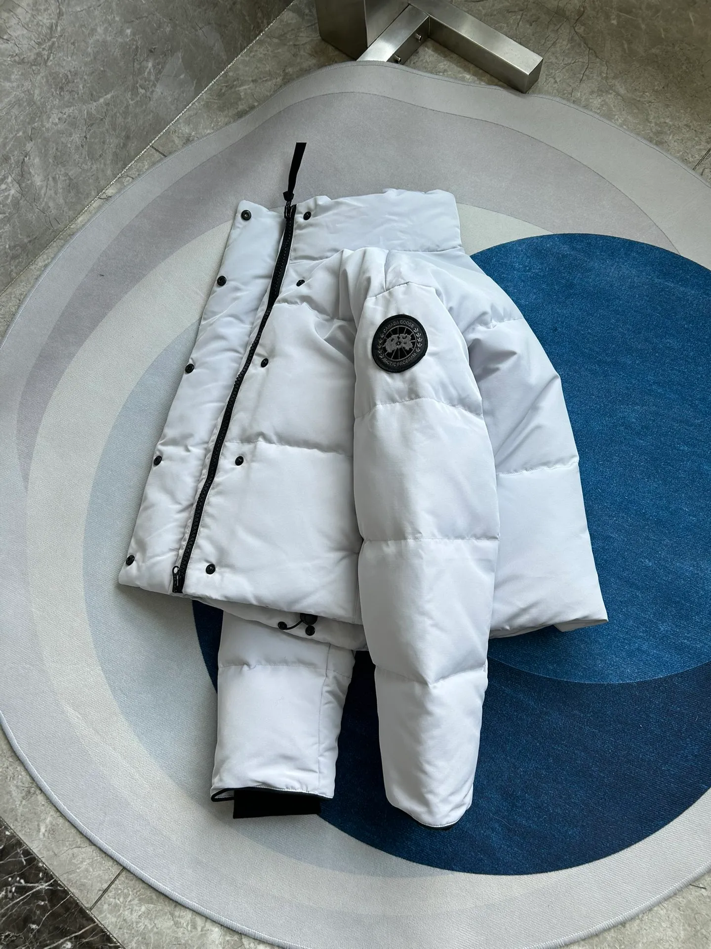 P880 E2266WB Grandview black label short jacket down jacket. Constructed from Arctic Tech recycled fabric®, it features a cinchable hem for sleek styling and storage. Color: White Star White. Size: XS S M L XL.